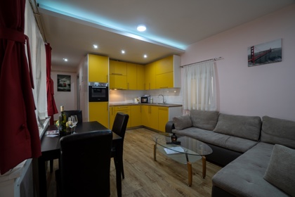 Apartman 1 – dnevni boravak s kutnom garniturom i stolom